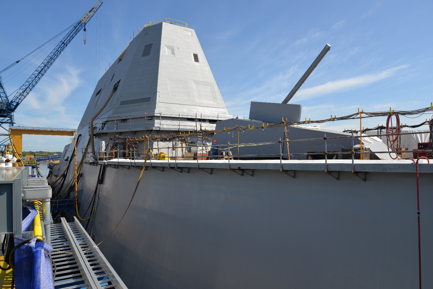 The forward and after decks are lined with vertical launchers able to handle a variety of missiles. The deck-edge scaffolding here is just outside the launchers, which are embedded in the side of the ship.