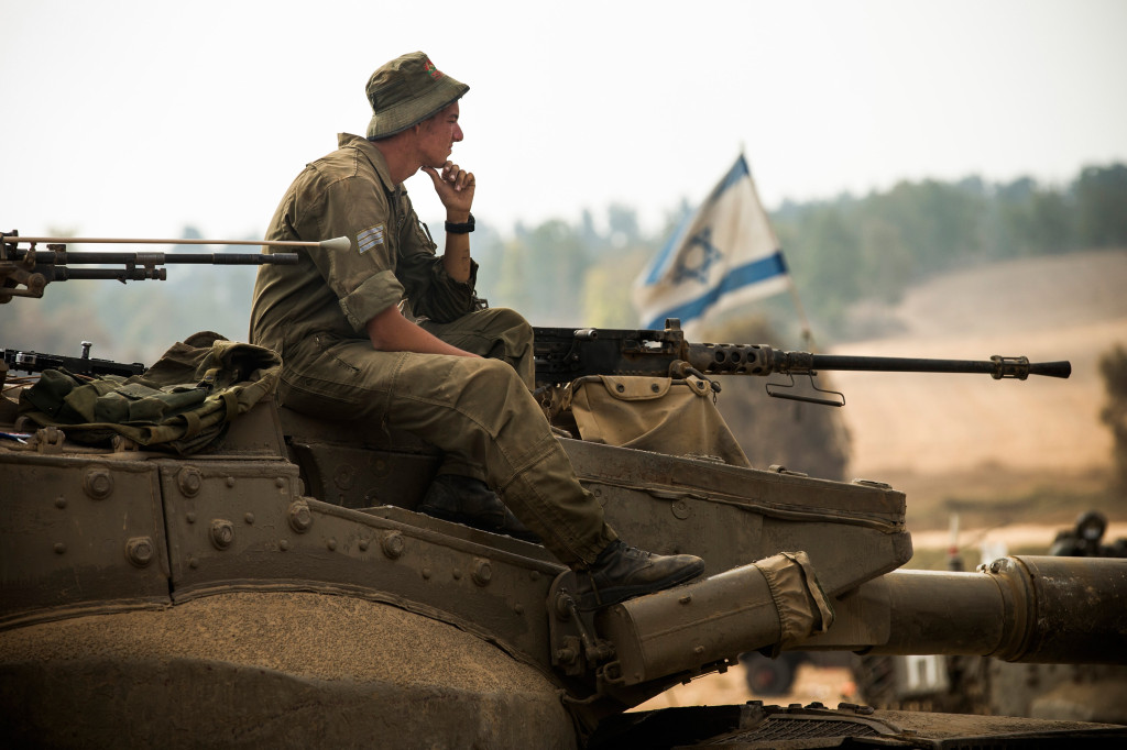 An Israeli soldier sits on a tank on July 28, near Kafar Azza, Israel. As Israel's operation 'Protective Edge' in Gaza continues, the international community struggles to find a truce agreement. (Andrew Burton/Getty Images)